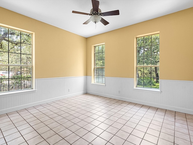 tiled spare room with a wealth of natural light and ceiling fan