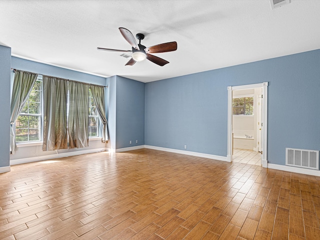 unfurnished room featuring ceiling fan and a textured ceiling