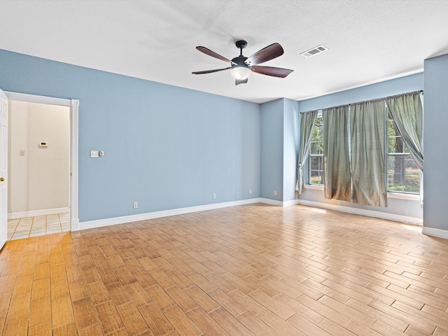 unfurnished room with ceiling fan and a textured ceiling