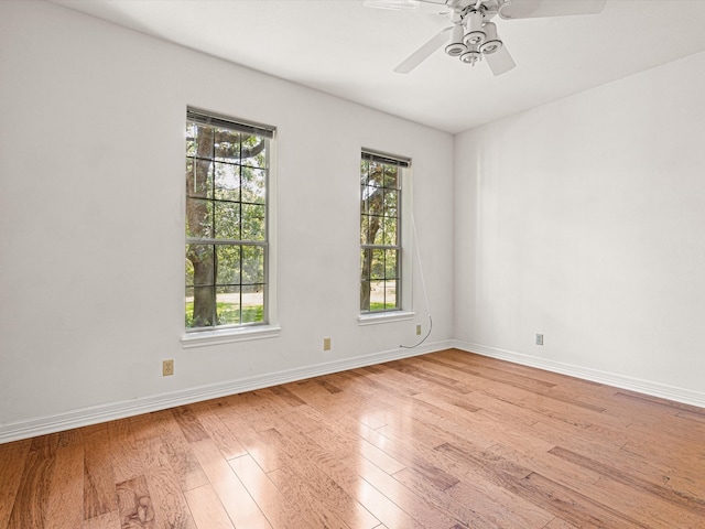 spare room featuring ceiling fan, a wealth of natural light, and light hardwood / wood-style flooring