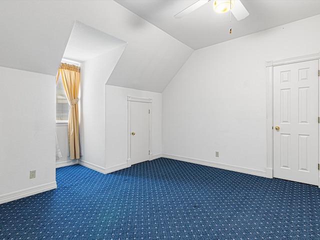 bonus room featuring ceiling fan, dark carpet, and lofted ceiling