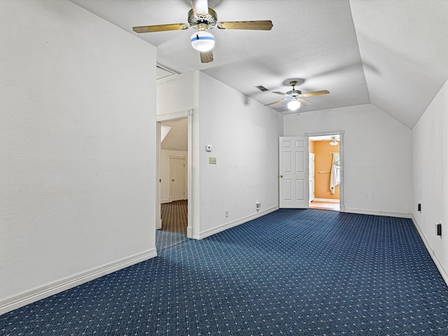 spare room featuring dark carpet, ceiling fan, and lofted ceiling