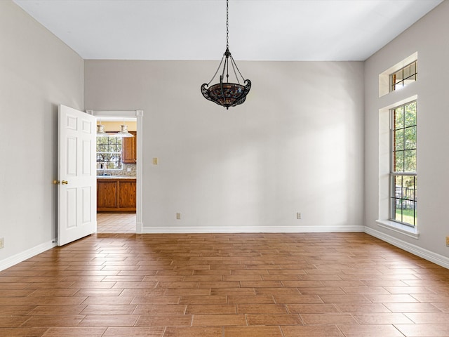 unfurnished room with a chandelier and plenty of natural light