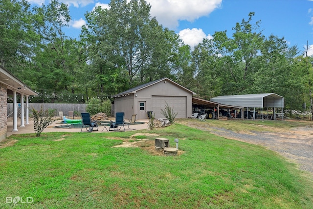 view of yard featuring a patio, a carport, an outbuilding, and a garage