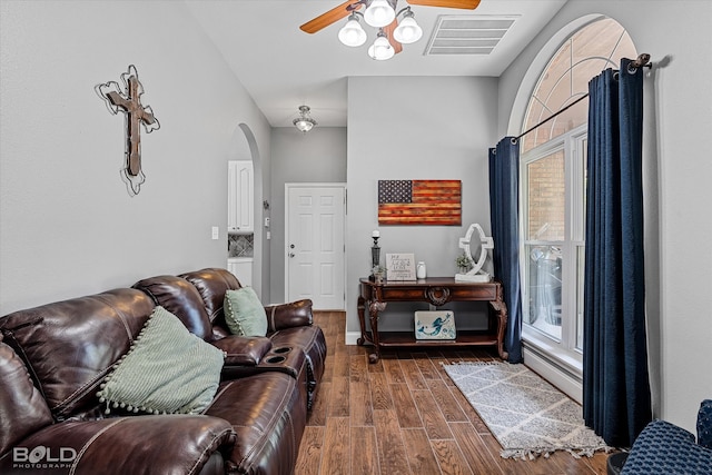 living room with ceiling fan and dark wood-type flooring