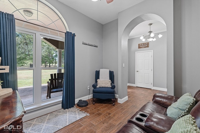 living room featuring ornamental molding, an inviting chandelier, and wood-type flooring