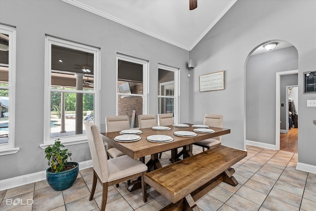 dining room with ceiling fan, light tile patterned flooring, crown molding, and lofted ceiling