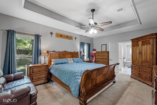 bedroom featuring ceiling fan, light carpet, and a tray ceiling