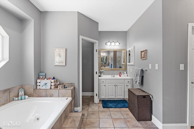 bathroom with tile patterned floors, a tub, and vanity