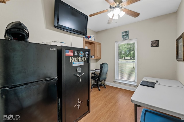 kitchen with light wood-type flooring, black refrigerator, ceiling fan, and light brown cabinetry