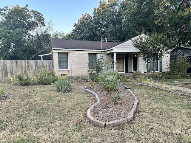 single story home featuring a front lawn