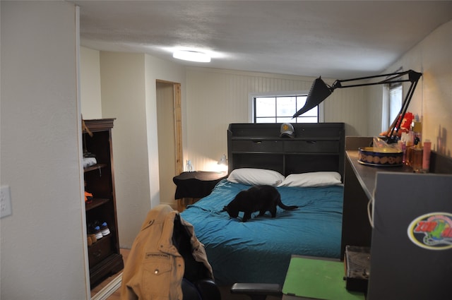 bedroom with a textured ceiling and vaulted ceiling