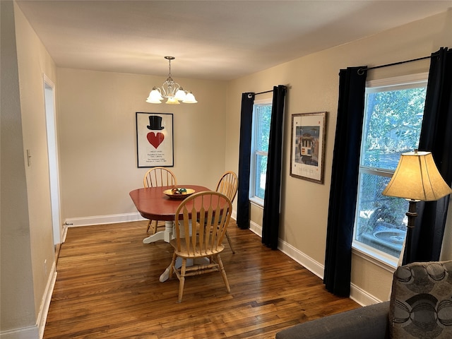 dining space featuring dark wood-type flooring, a chandelier, and a healthy amount of sunlight