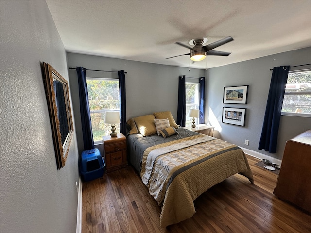 bedroom featuring multiple windows, ceiling fan, and dark hardwood / wood-style flooring