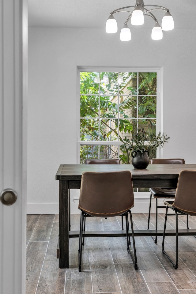 dining room with wood-type flooring and a notable chandelier