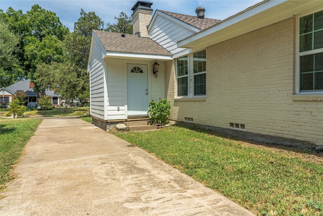 doorway to property with a yard