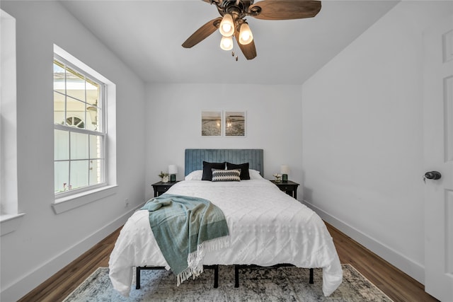 bedroom with dark wood-type flooring, multiple windows, and ceiling fan