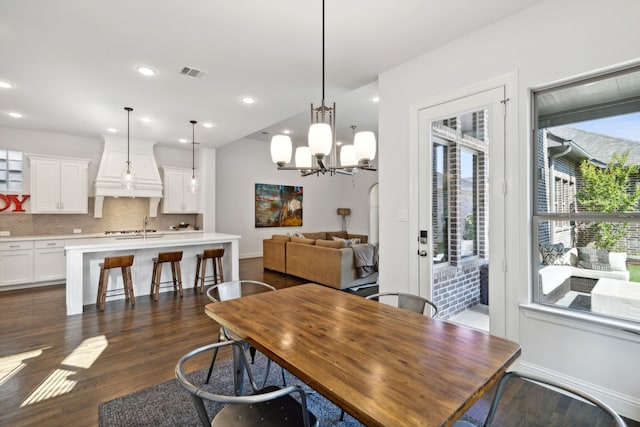 dining room with a notable chandelier, dark hardwood / wood-style flooring, and sink