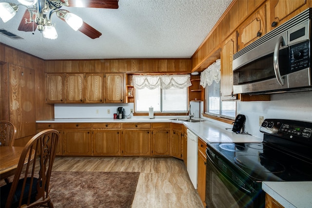 kitchen featuring white dishwasher, a textured ceiling, black / electric stove, sink, and ceiling fan