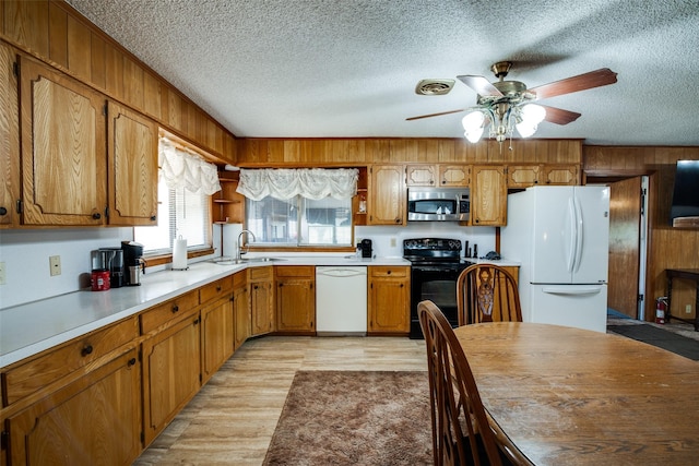 kitchen featuring white appliances, a textured ceiling, sink, light wood-type flooring, and ceiling fan