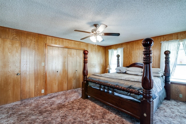 bedroom with ceiling fan, dark carpet, and wood walls