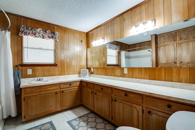 bathroom with tile patterned flooring, curtained shower, a textured ceiling, vanity, and wood walls