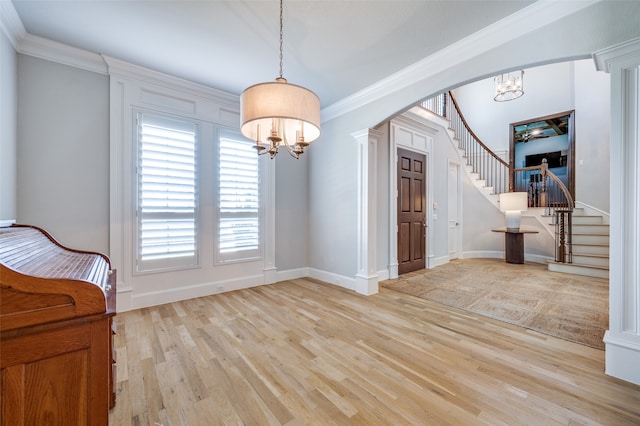 interior space featuring crown molding, light hardwood / wood-style flooring, and a chandelier