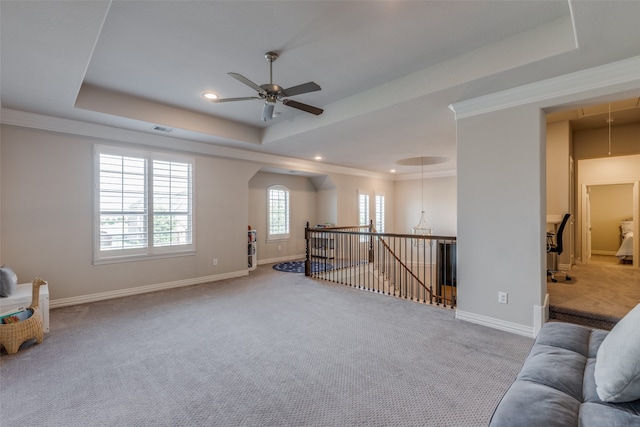 interior space with ornamental molding, a raised ceiling, and ceiling fan