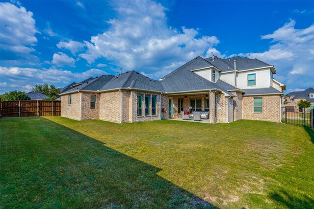 rear view of house featuring a yard and a patio