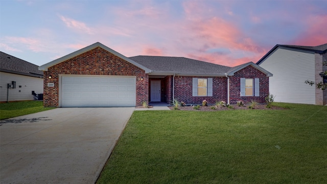 ranch-style home featuring a garage and a yard