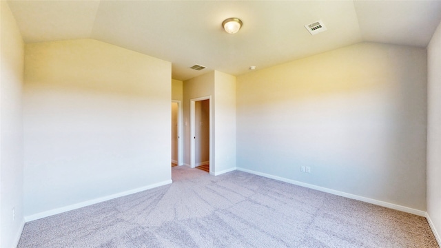 carpeted spare room featuring lofted ceiling