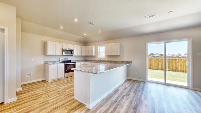 kitchen with white cabinets, stainless steel appliances, and kitchen peninsula