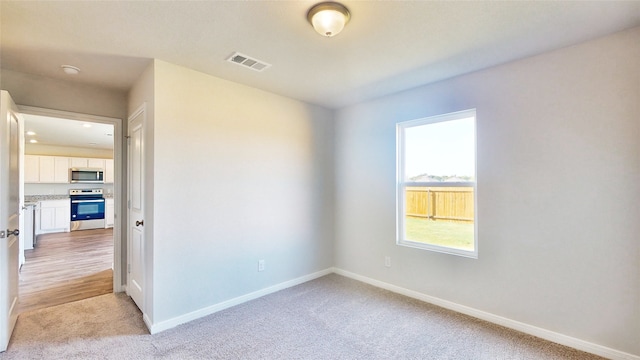 spare room featuring light colored carpet