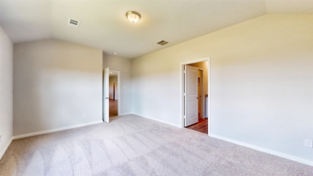 unfurnished bedroom with lofted ceiling and carpet