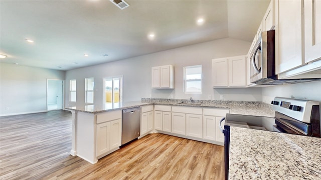 kitchen featuring light stone counters, white cabinets, light hardwood / wood-style floors, kitchen peninsula, and appliances with stainless steel finishes