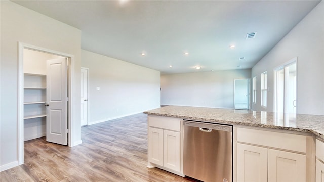 kitchen with white cabinets, dishwasher, light stone countertops, and light hardwood / wood-style floors