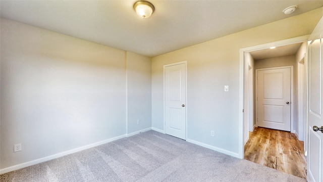 unfurnished bedroom featuring light carpet and a closet