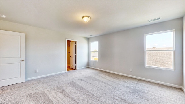 spare room featuring light colored carpet