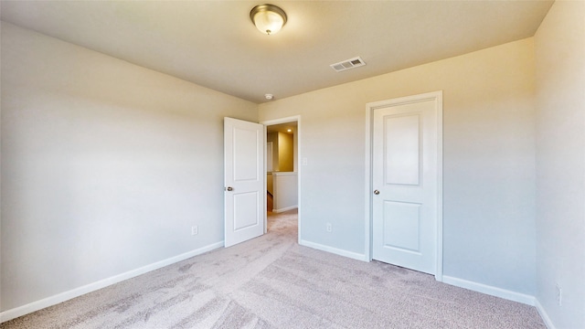 unfurnished bedroom with a closet and light colored carpet