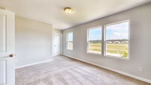 unfurnished room featuring light carpet