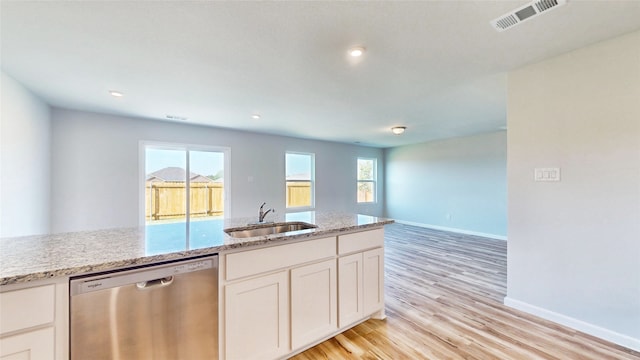 kitchen featuring light stone counters, sink, stainless steel dishwasher, white cabinetry, and light wood-type flooring