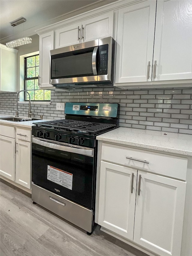 kitchen featuring light wood-type flooring, backsplash, sink, and stainless steel appliances