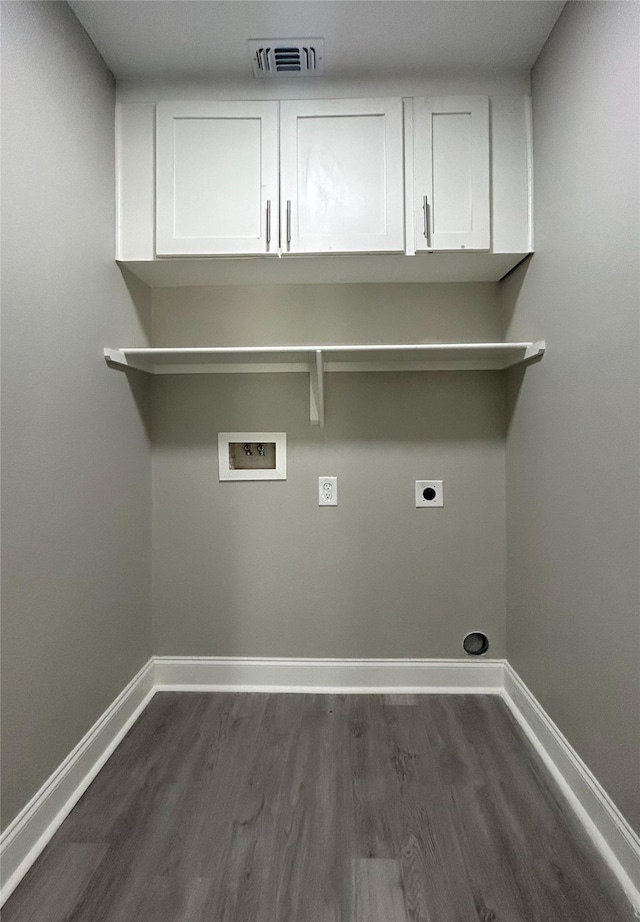 laundry room featuring dark wood-type flooring, cabinets, hookup for a washing machine, and hookup for an electric dryer