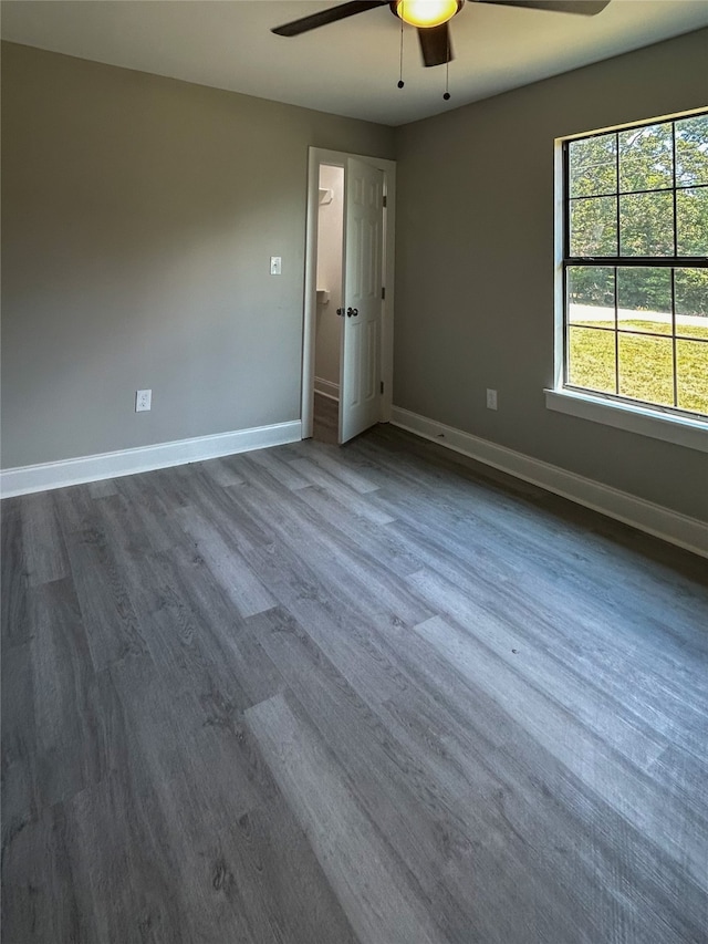 empty room with ceiling fan and dark wood-type flooring