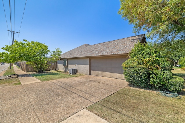 exterior space featuring a garage, central AC, and a yard