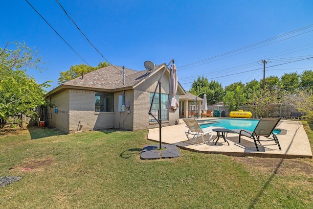 back of property featuring a patio, a fenced in pool, and a yard