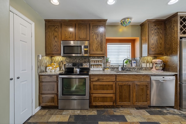 kitchen featuring appliances with stainless steel finishes, dark tile patterned flooring, sink, and backsplash