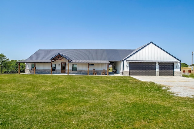 view of front of property featuring a porch, a garage, and a front lawn