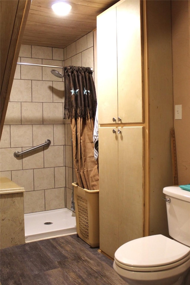 bathroom featuring wooden ceiling, wood finished floors, a shower stall, and toilet