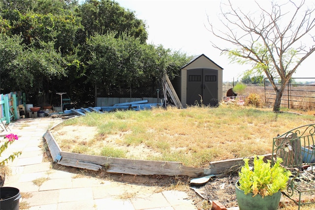view of yard with an outbuilding, a shed, and fence